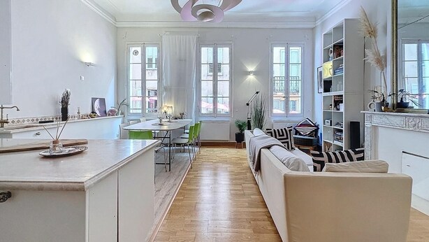 Eine moderne Küche mit Essbereich, Holzboden und einem großen Fenster.