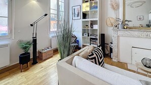 Ein modernes Wohnzimmer mit einer Couch, einem Bücherregal, einem Kamin und einem großen Fenster.