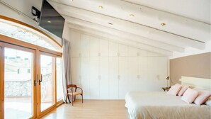 Un dormitorio moderno con una cama grande, una silla y un armario.