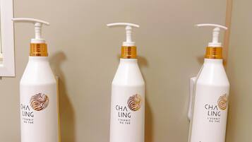 Three bottles of Cha Ling shampoo and conditioner on a wall.