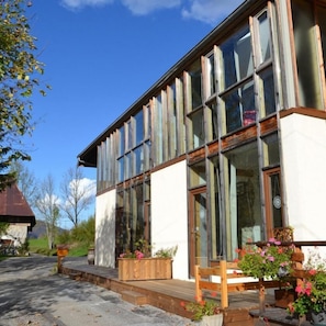 A modern building with large windows and a wooden deck.