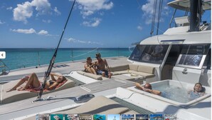 A yacht with a spacious deck, a hot tub, and a seating area with a view of the ocean. - MUST SELL 1-3 wks ALL INCLUSIVE crewed BVI private yacht charter FP 67 Catamaran (Tortola)