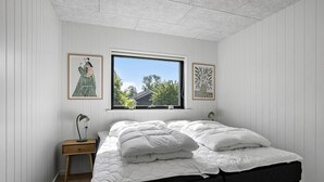 Une chambre à coucher avec un lit, une fenêtre et deux tables de chevet.