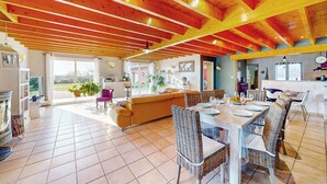 A spacious living area with a high ceiling, a dining table set for six, and a large window offering a view of the outdoors. - Pet friendly home in Eyraud-Crempse-Maurens (Eyraud-Crempse-Maurens)