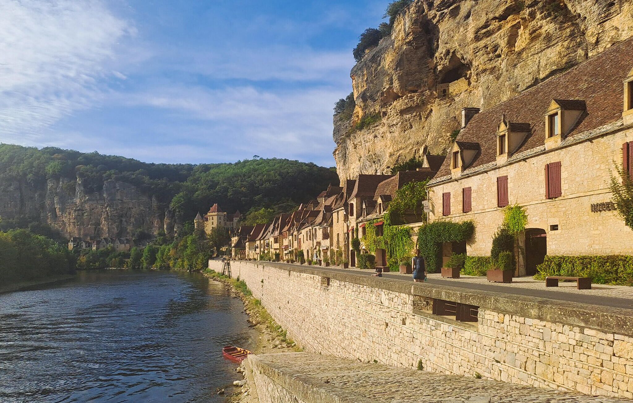 Une ville riveraine aux bâtiments en pierre, dotée d’un château et bordée par une rivi ère.