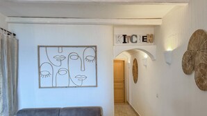 A living room with a gray sofa, a wall art piece, and a sign that reads "ICE". - Stunning home in Castelsardo with WiFi (Castelsardo)