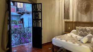 A bedroom with a bed, curtains, and a decorative wall piece. - HOTEL ALEIA. Centro (Taxco)