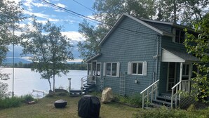 Una casa con un muelle, una parrilla cubierta y vistas al lago.