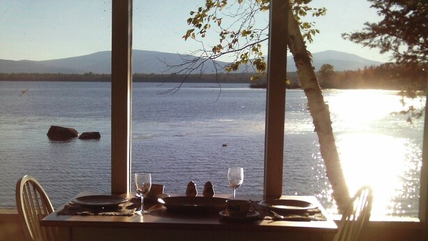 Una mesa para dos con vista a un lago y montañas.