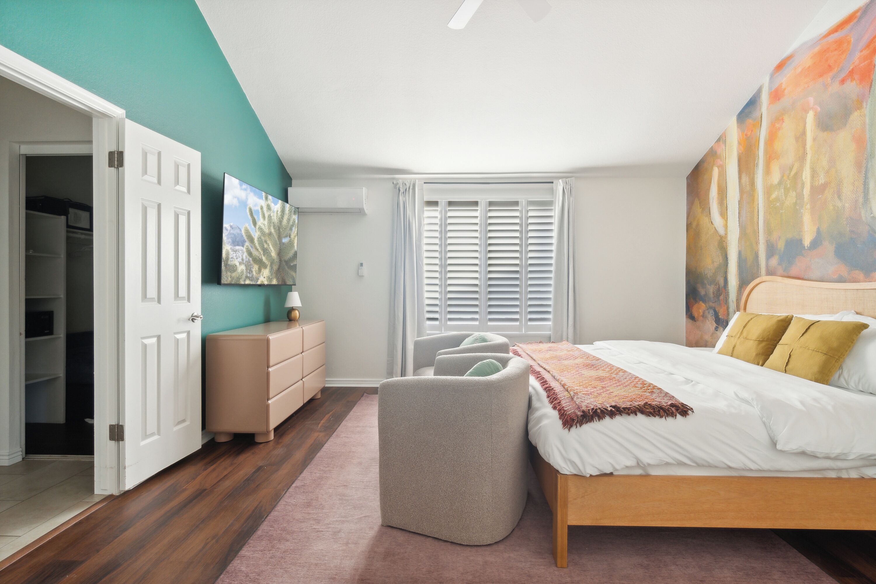 Une chambre à coucher avec un lit, une commode, une chaise et un placard.