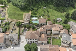 Vista aérea de un pueblo histórico con arquitectura tradicional, un patio central y una piscina.