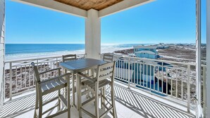 Un balcón techado con vistas al océano y la playa.