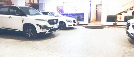 A parking area with three white cars parked in a row.