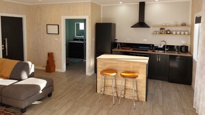 A modern kitchen with a central island, bar stools, and a built-in oven. - Nine on Cochrane - relax, unwind and explore Rotorua. (Rotorua)