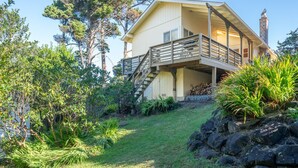 Uma casa de dois andares com uma escada de madeira que dá para uma varanda.
