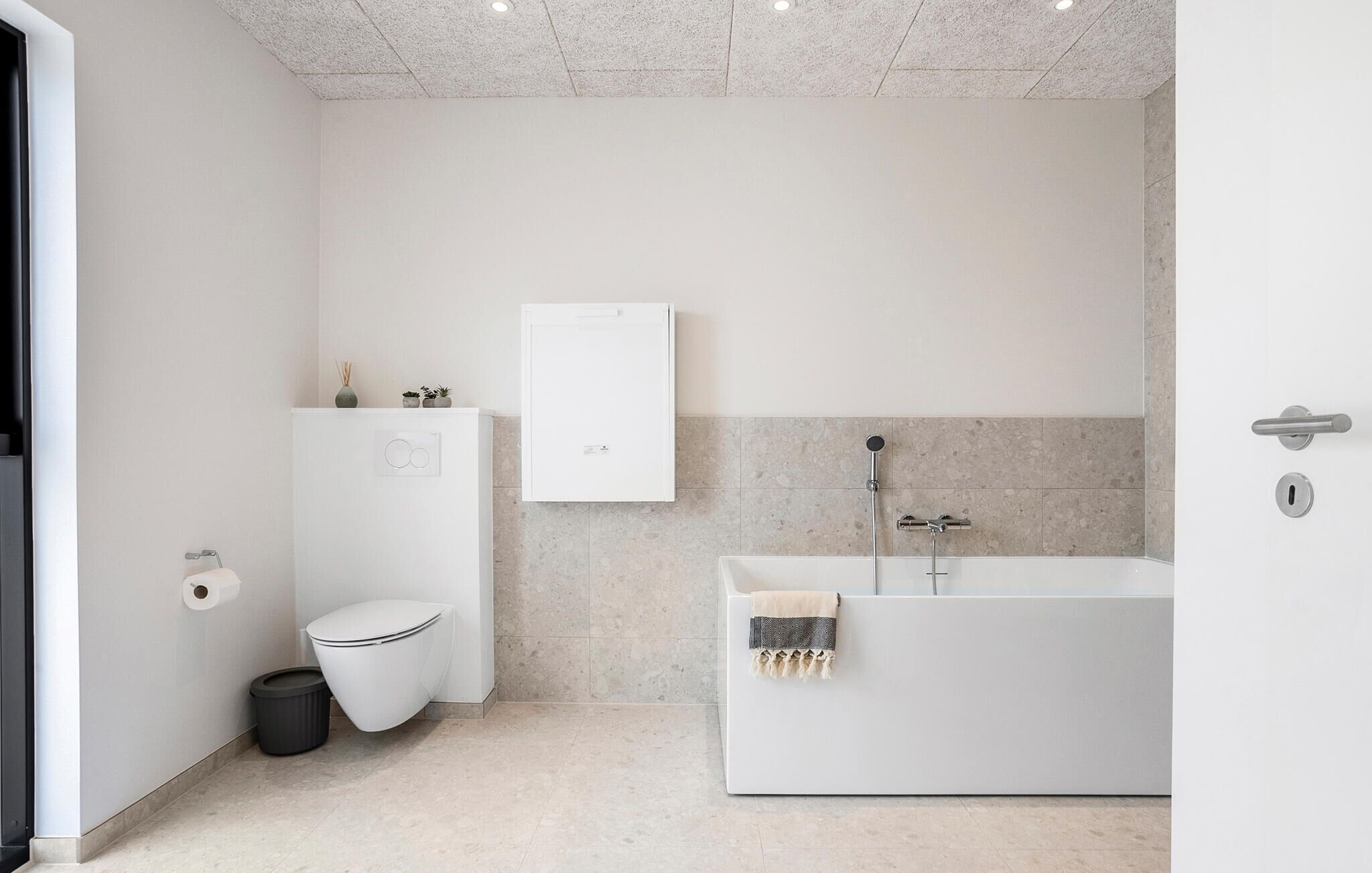 Une salle de bain moderne équipée de toilettes, d’un meuble et d’une baignoire.