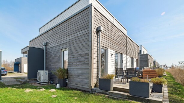 A modern two-story house with a flat roof, large windows, and a small porch area with outdoor seating. - 2 bedroom awesome home in Tossens (Tossens)