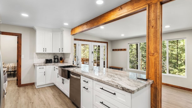 A modern kitchen with white cabinets, a granite countertop, and a wooden beam ceiling. - MTNSIDE Cabin with VIEWS by LYNX LAKE 20 min to TOWN (Prescott)