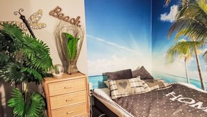 A bedroom with a bed, a dresser, and a wall mural of a beach scene. - Bocksbergperle 3 by Interhome (Hahnenklee)