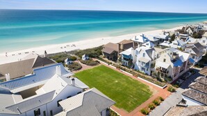 A coastal residential area with houses, a beach, and a clear view of the ocean.