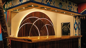 Un comptoir d’accueil avec un revêtement en bois et un éclairage moderne.
