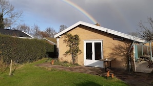 Une maison de plain-pied avec une façade en briques et une porte blanche.