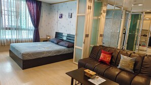 Ein modernes Schlafzimmer mit einem großen Bett, einem Ledersofa und einem kleinen Tisch.