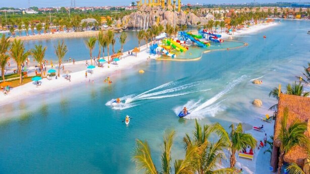 A water park with a sandy beach, water slides, and a large water attraction. - Bay Luxury Villa OCP2 - Self Checkin (Nghia Tru)