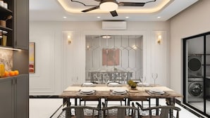A modern dining room with a large table set for six, a ceiling fan, and a built-in washer and dryer. - Bay Luxury Villa OCP2 - Self Checkin (Nghia Tru)