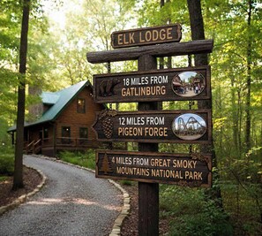 Un cartel de madera con indicaciones de distancia a Elk Lodge, Gatlinburg, Pigeon Forge y Parque Nacional de las Montañas Humeantes.