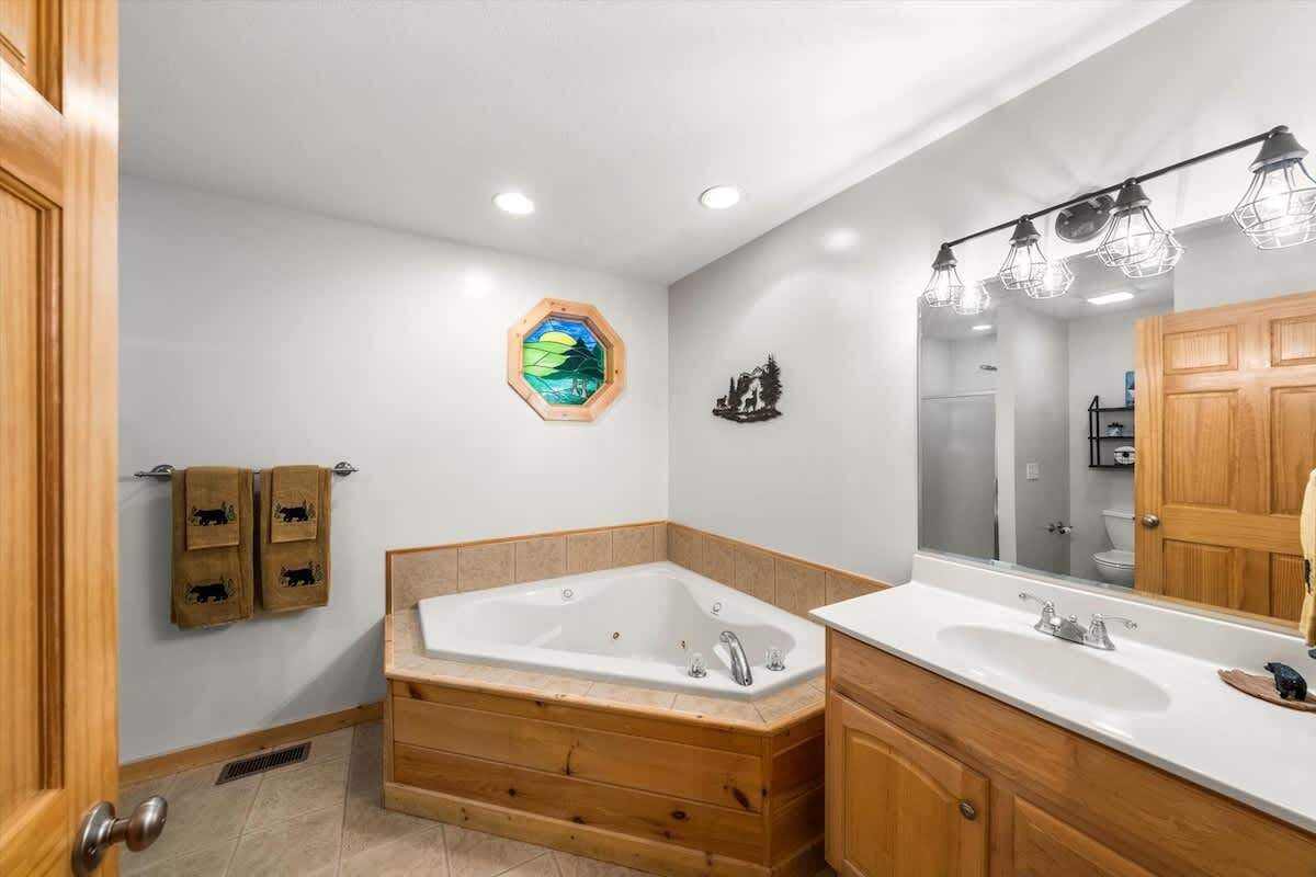 Une salle de bain moderne avec une baignoire sur pieds, un meuble-lavabo en bois et un grand miroir.