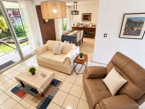 Una sala de estar con un sofá, una mesa de centro y un comedor con una mesa y sillas.