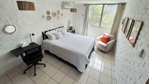 Ein Schlafzimmer mit Bett, Schreibtisch, Stuhl und Fenster.
