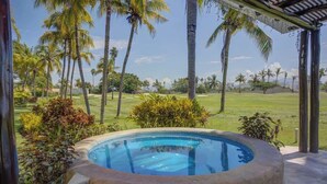 A hot tub surrounded by palm trees and a golf course. - El Tigre Deluxe Stay w/ Pool & Golf views. Large Terrace & BBQ (Nuevo Vallarta)