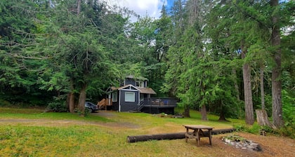 Riverfront cottage with stairs to the river, firepit, and forested retreat.
