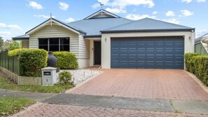 A two-story house with a garage, a brick driveway, and a mailbox. - Warm, Cosy winter getaway with Hot Chocolate and Coffee and Heating every room! (Vasse)
