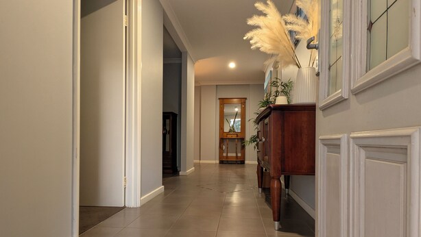 A hallway with a wooden cabinet, a mirror, and a door leading to another room. - Warm, Cosy winter getaway with Hot Chocolate and Coffee and Heating every room! (Vasse)