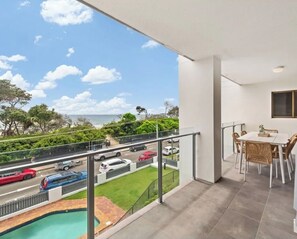 Een balkon met uitzicht op een weg en een zwembad.