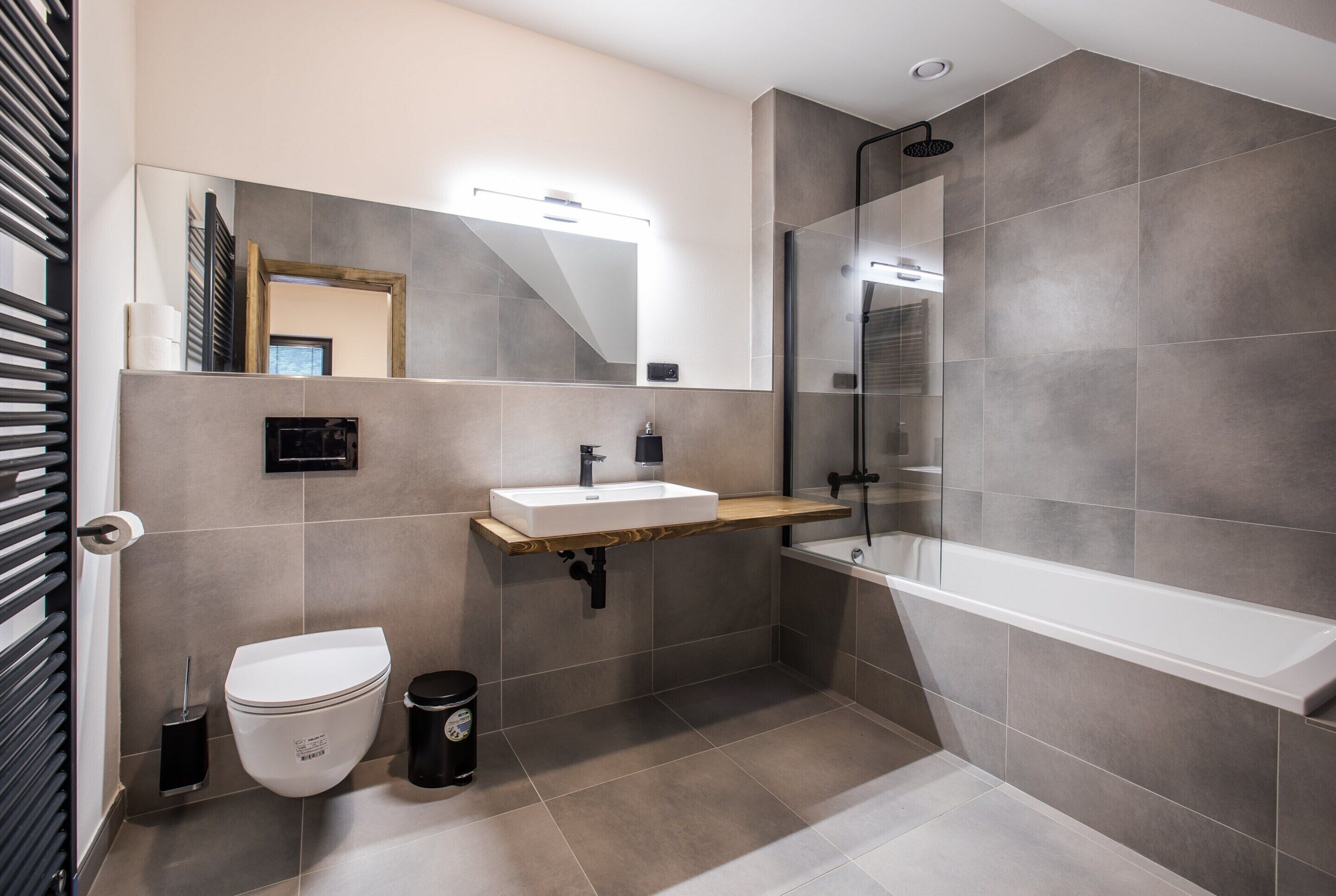 Un baño moderno con inodoro, lavamanos y ducha.