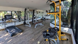 Una palestra moderna con macchinari cardio, attrezzature per sollevamento pesi e una panca.