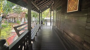 Una passerella in legno riparata, con panchine, un'opera d'arte incorniciata al muro e vista sulla zona circostante.