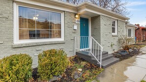 A residential house with a blue door, number 709, a front porch with a white railing, and a large window. - Charming 3-bedroom house near downtown Boise with AC, WiFi (Boise)