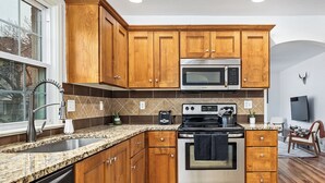 A kitchen with wooden cabinets, a stainless steel oven, a microwave, and a dishwasher. - Charming 3-bedroom house near downtown Boise with AC, WiFi (Boise)