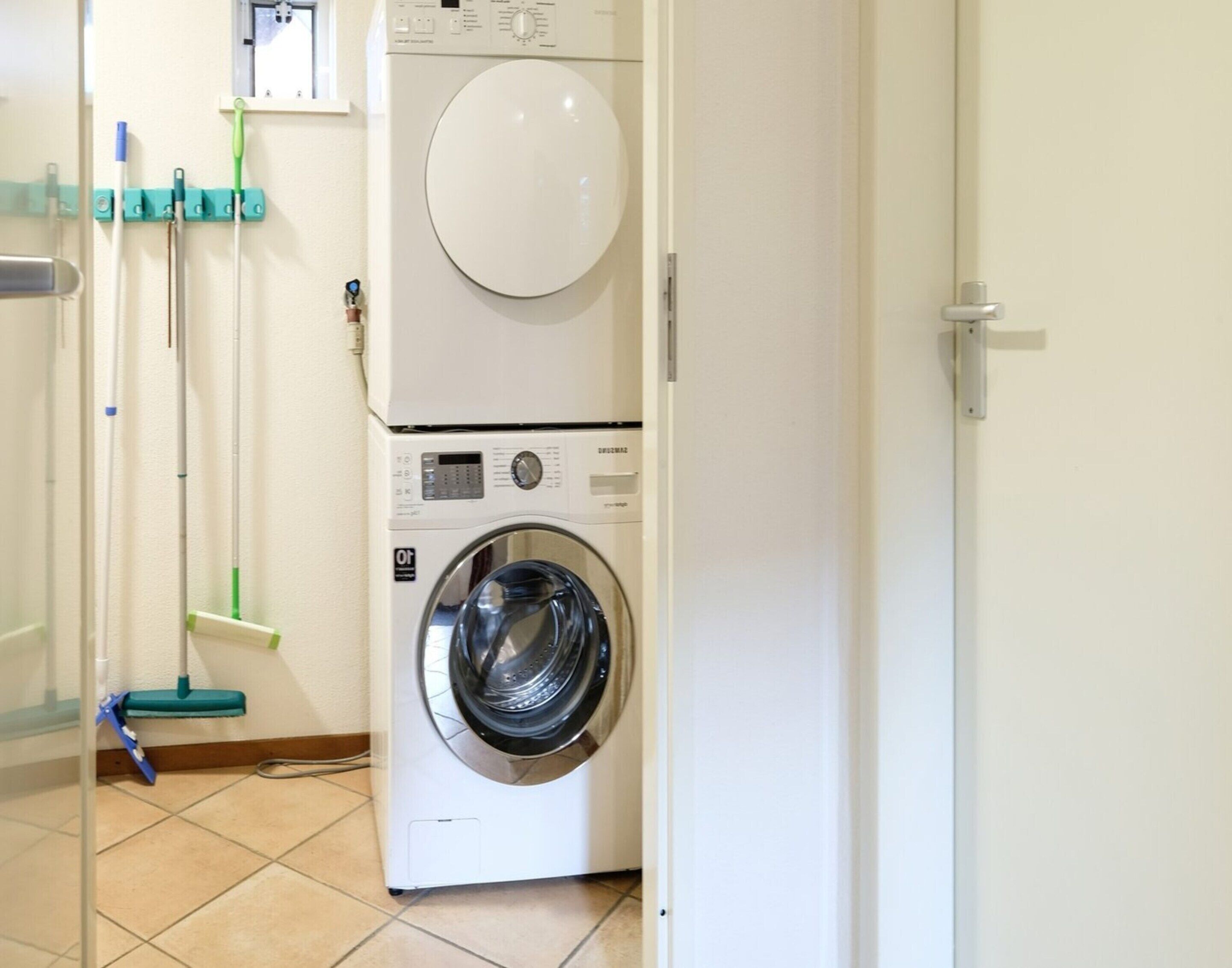 A laundry area with a front-loading washing machine and dryer stacked on top of each other.