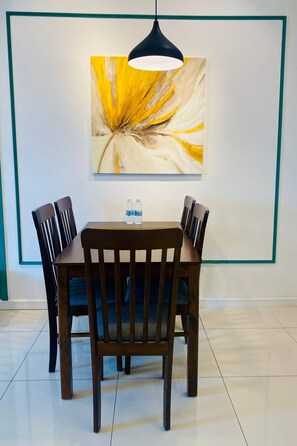 Un comedor con una mesa, sillas y un cuadro en la pared.