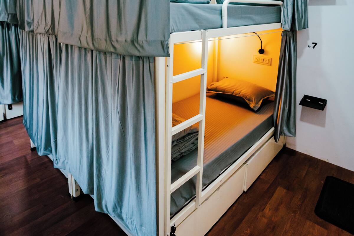 A bunk bed with a ladder, a desk, and a chair.