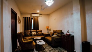 A living room with a sofa set, a coffee table, a lamp, and a ceiling fan. - Half Orange (Vagator)
