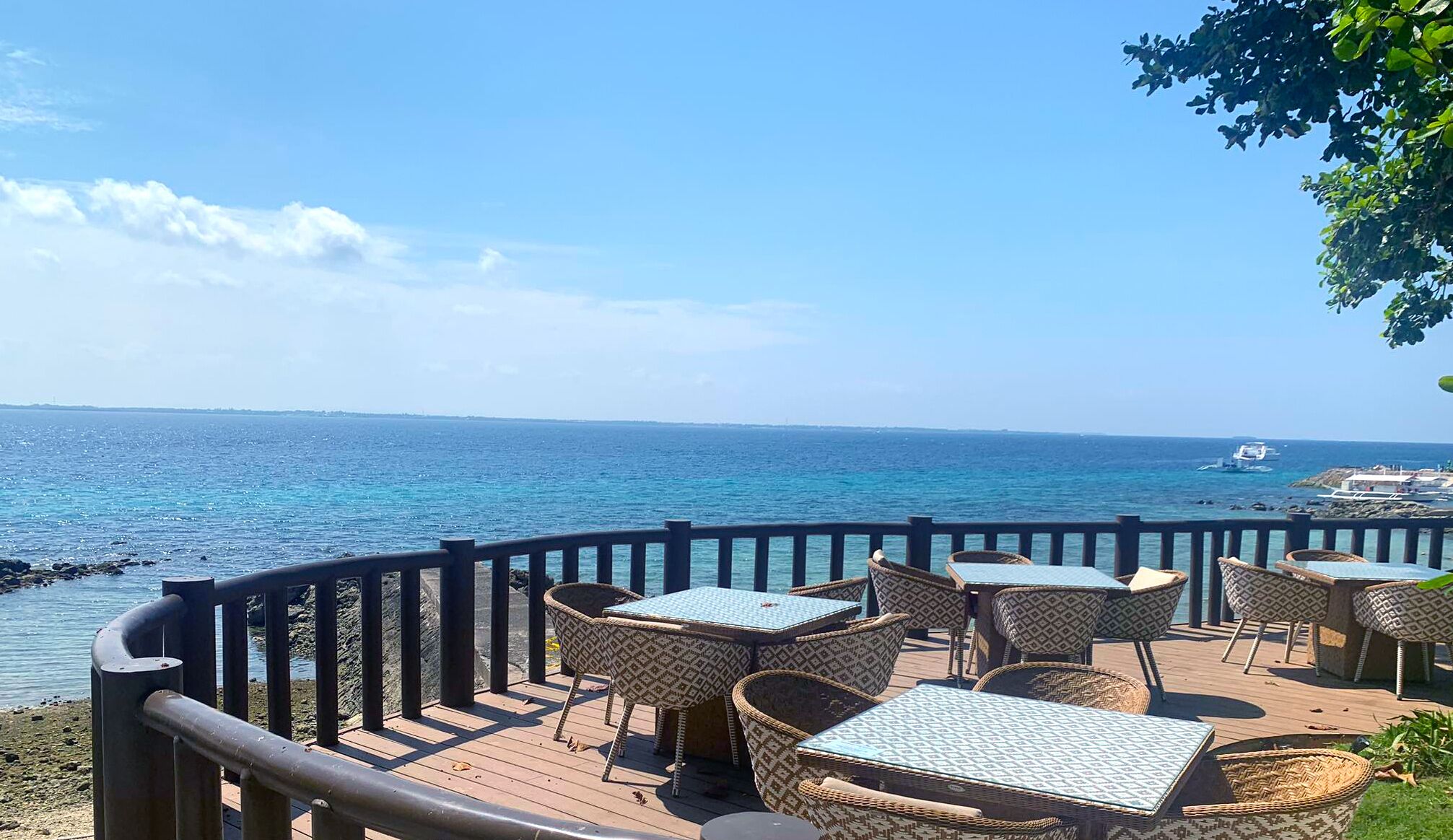 Eine Strandterrasse mit Korbmöbeln und Blick auf das Meer.