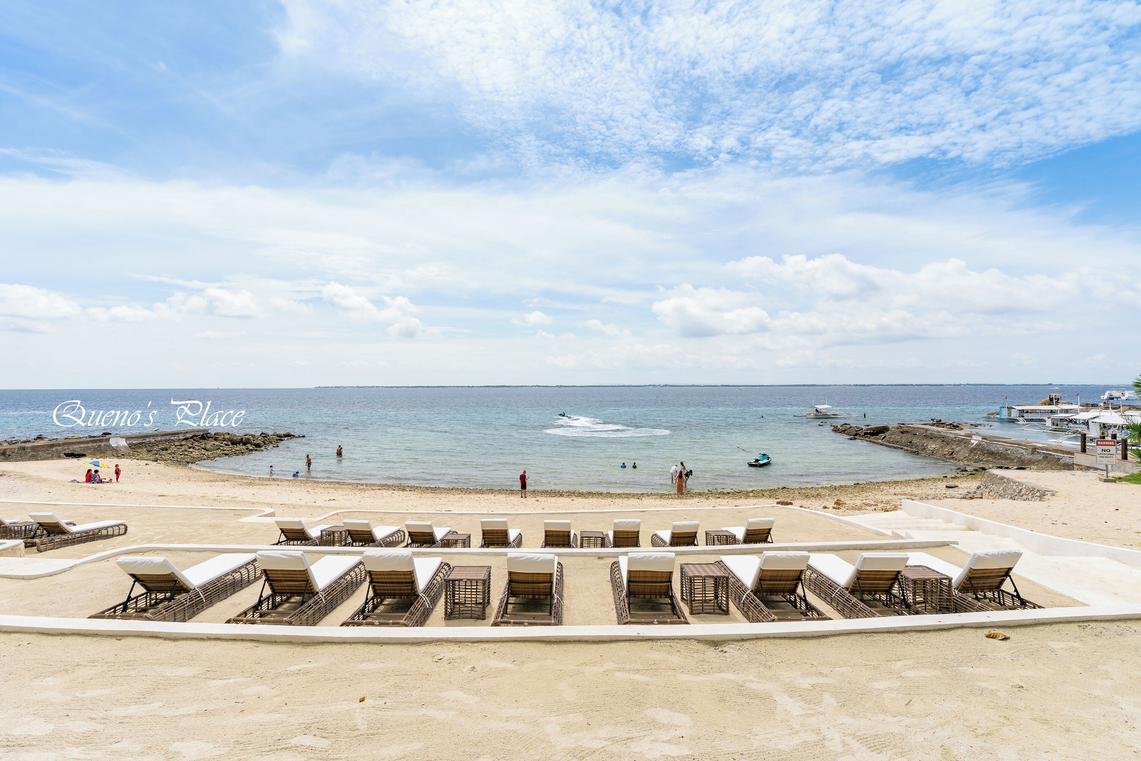 Une plage avec des chaises longues et une vue sur l’océan.