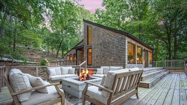 A wooden deck with outdoor furniture and a fire pit.